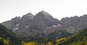 Maroon Bells, seen in front of a lake and with a snow-capped peak, one of the best fall hikes in the West