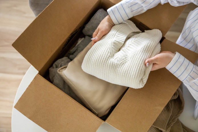 Woman putting sweater in cardboard box