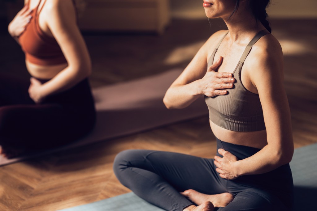 Women deep breathing in yoga studio