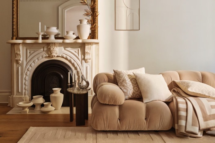 Cream and beige living room with a couch and fireplace accented with several vases