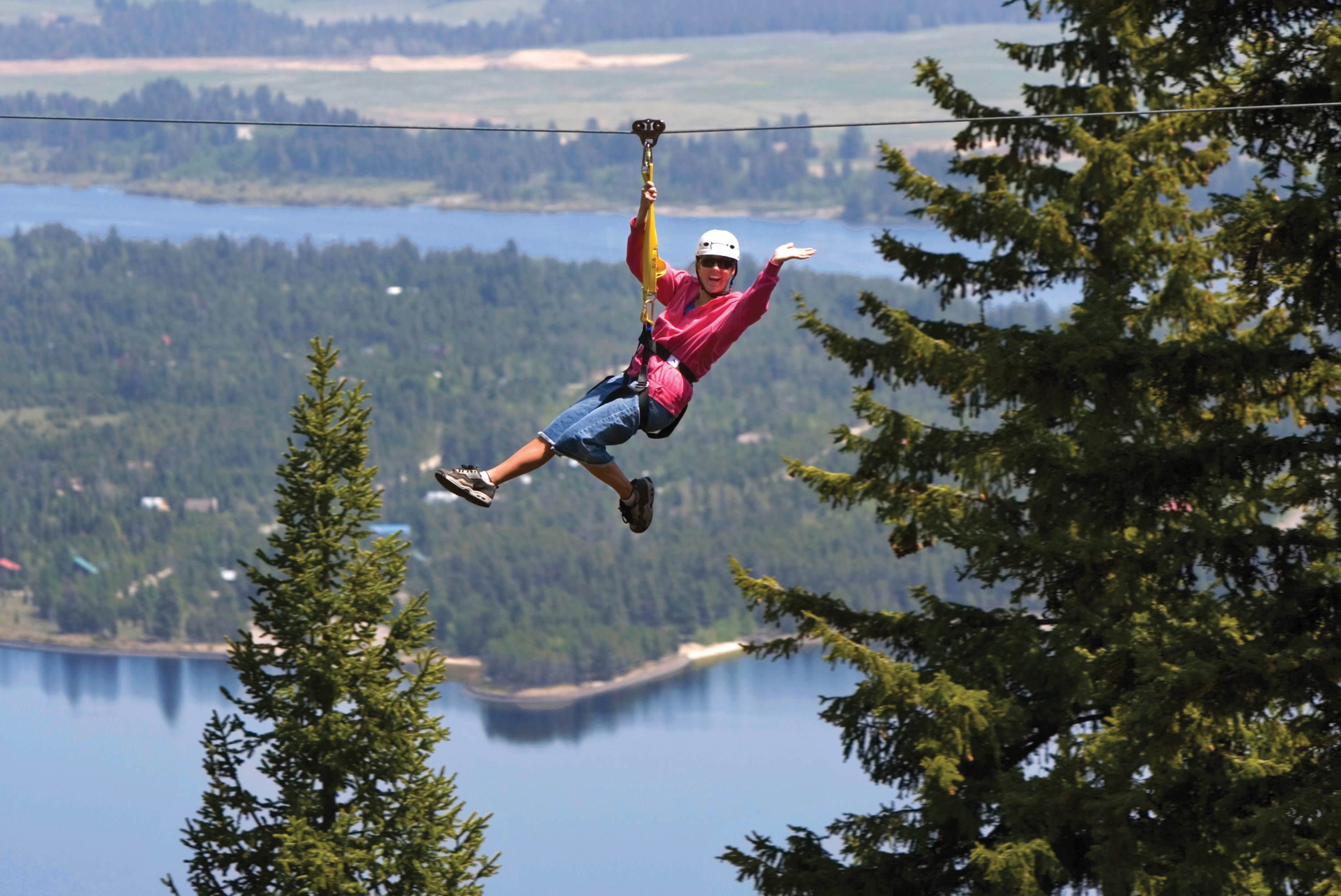 a-guest-at-tamarack-resort-soars-down-the-zip-line-course-high-above-lake-cascade