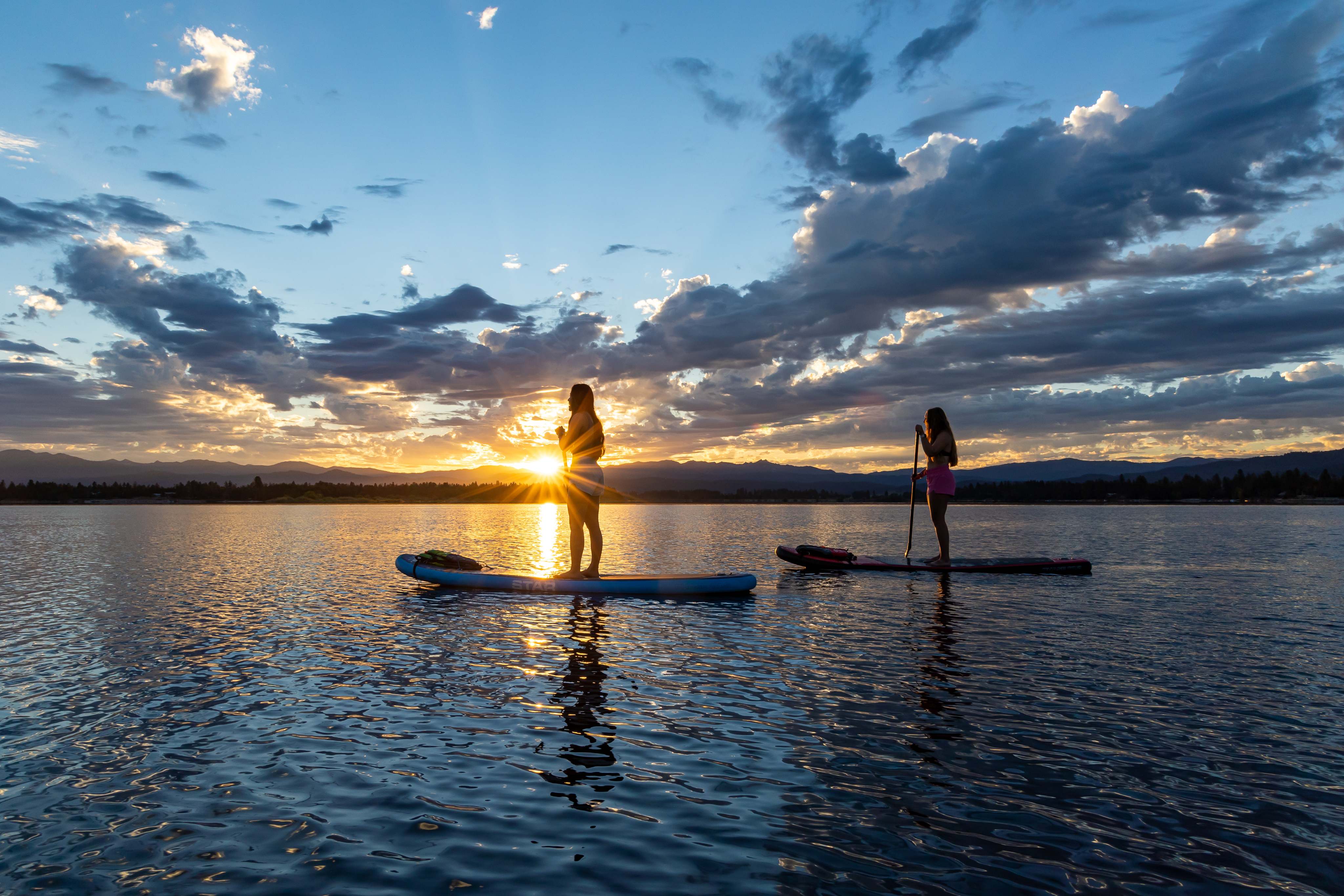 visitors-at-tamarack-resort-watch-sunset-from-their-paddle-boards-on-the-tranquil-lake-cascade