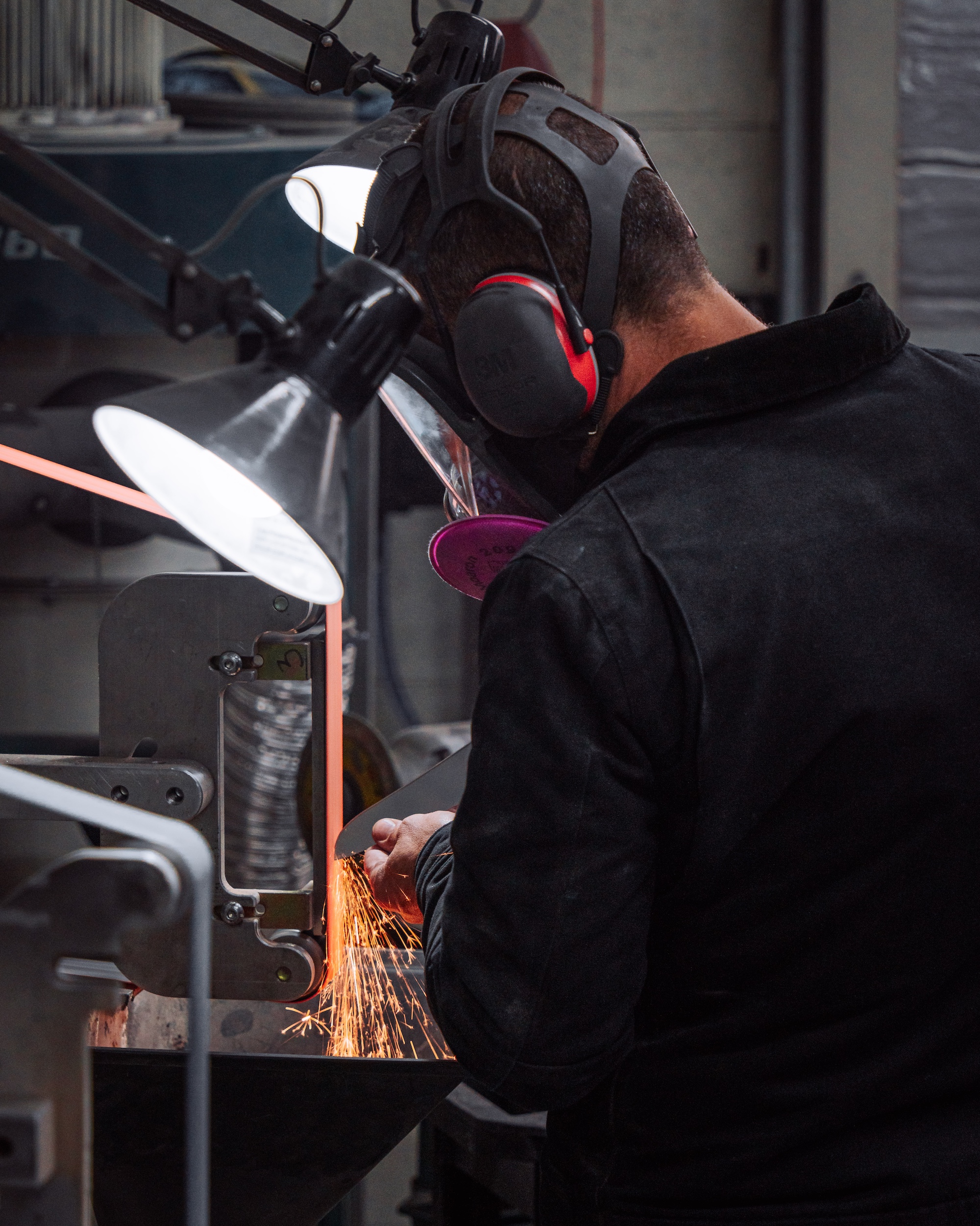 bladesmith-eytan-zias-using-grinding-machines-at-the-steelport-factory-during-a-tour