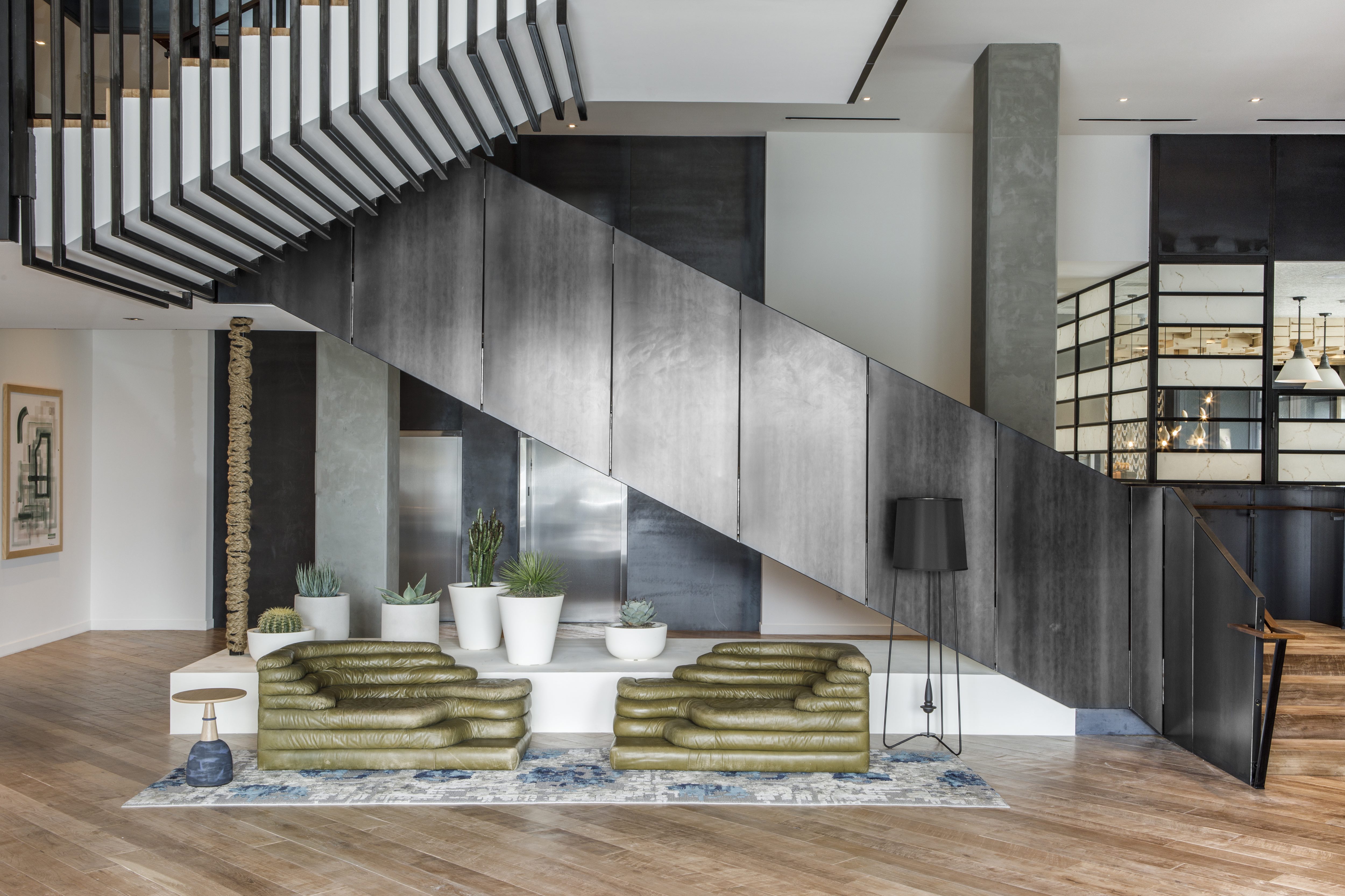 a-pair-of-de-sede-terrazza-sofas-beneath-the-sculptural-grand-stair-creates-a-striking-first-impression-in-the-lobby