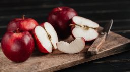 Red apples on a cutting board.