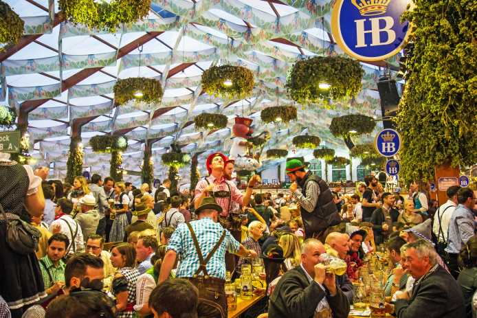 Oktoberfest beer hall with people drinking and talking.