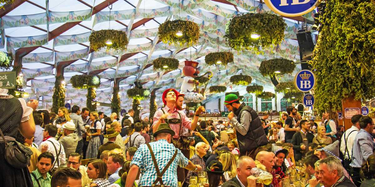 Oktoberfest beer hall with people drinking and talking.