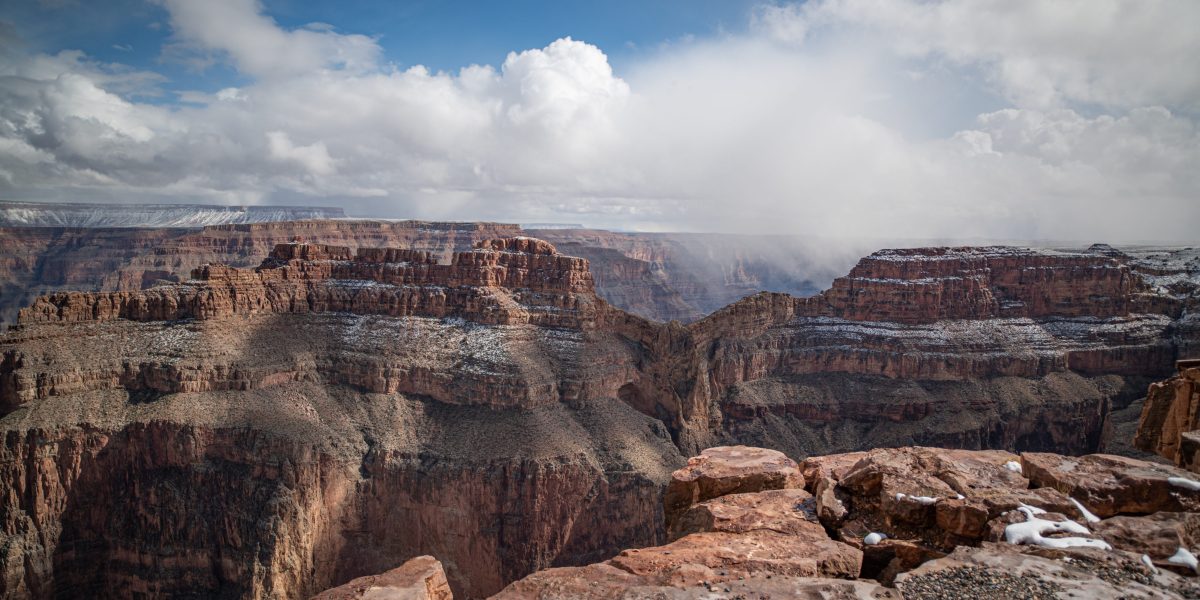 Steep drop into Grand Canyon with snow storms moving in in the distance