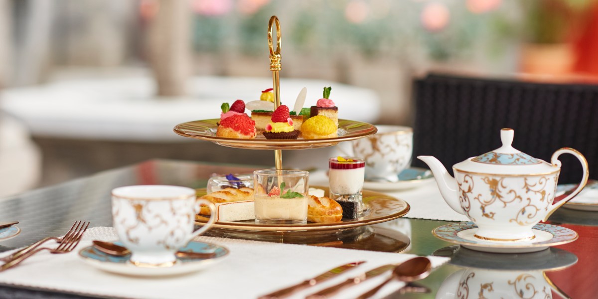 A tray of pastries, teapot, cup, and saucer