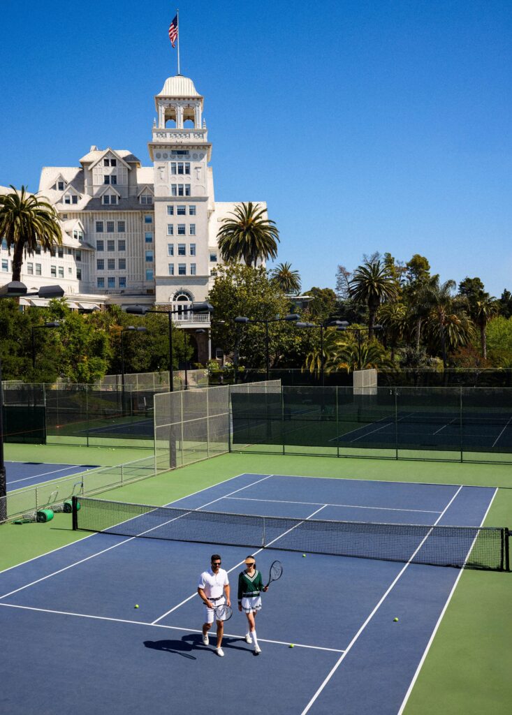 The exterior of a hotel with several tennis courts.