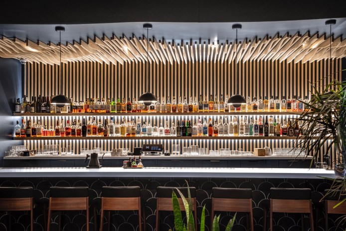 A long bar with shelves of liquor.
