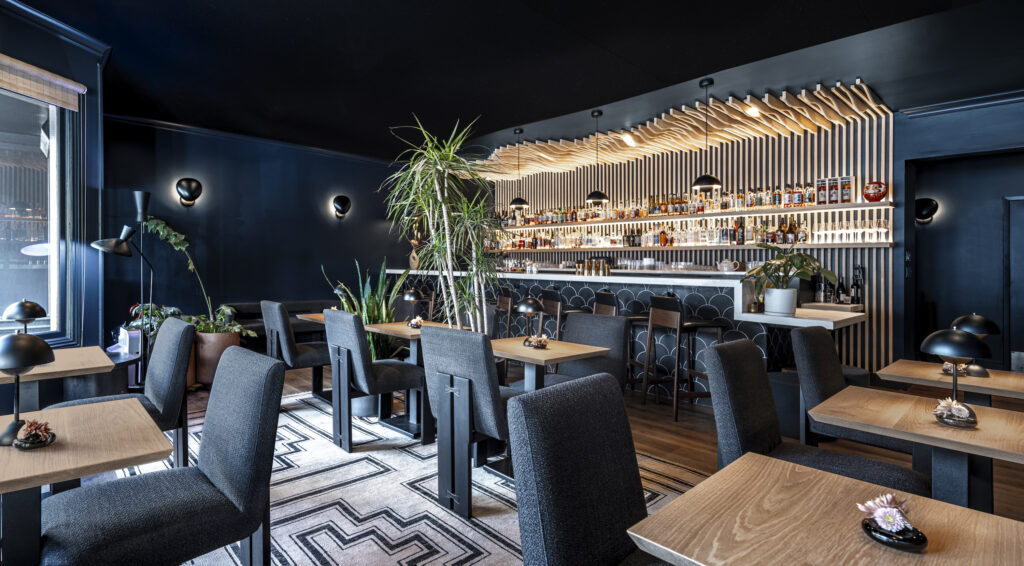 The inside of a bar with wood and dark interiors.