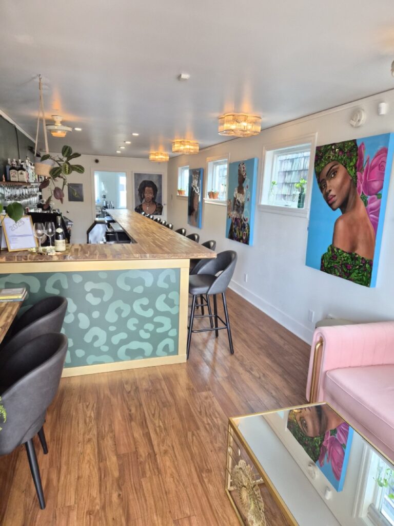 The inside of a bar with several pieces of artwork on the walls.