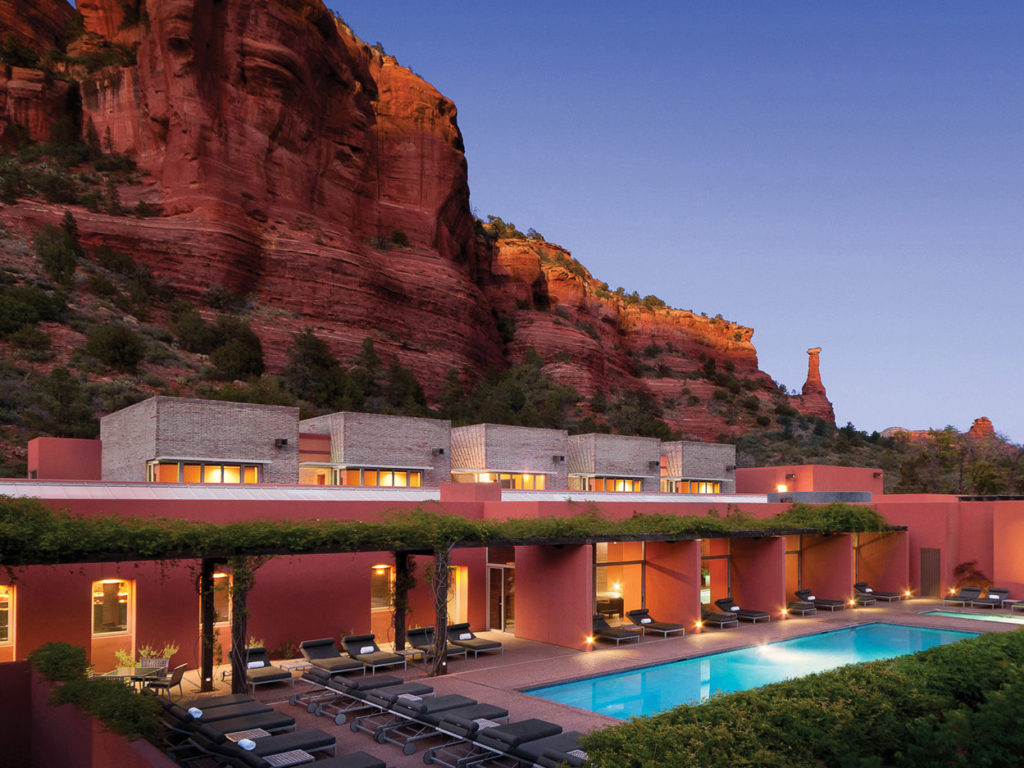 View of the red rock cliffs with pool at dusk at L'Auberge de Sedona