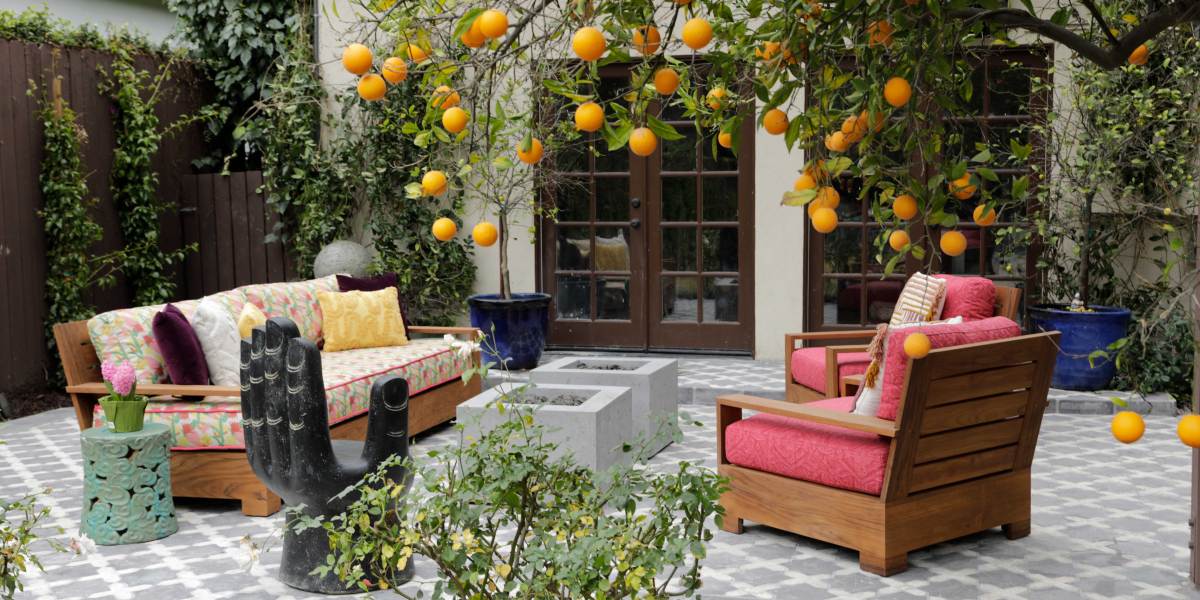 An orange tree hangs over two square, raw concrete fire pits
