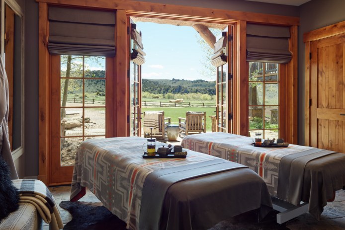 Two massage beds in a treatment room overlooking a ranch.