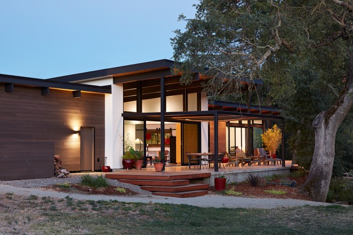 Klopf Architecture in Sacramento designed this single-story modern house with intense summer heat in mind, building a patio under the shade of a mature oak with a large overhang.