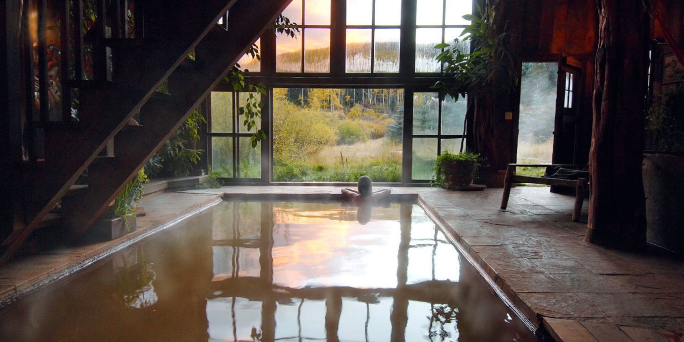 Woman soaking in the indoor hot springs pool at Dunton Hot Springs Resort