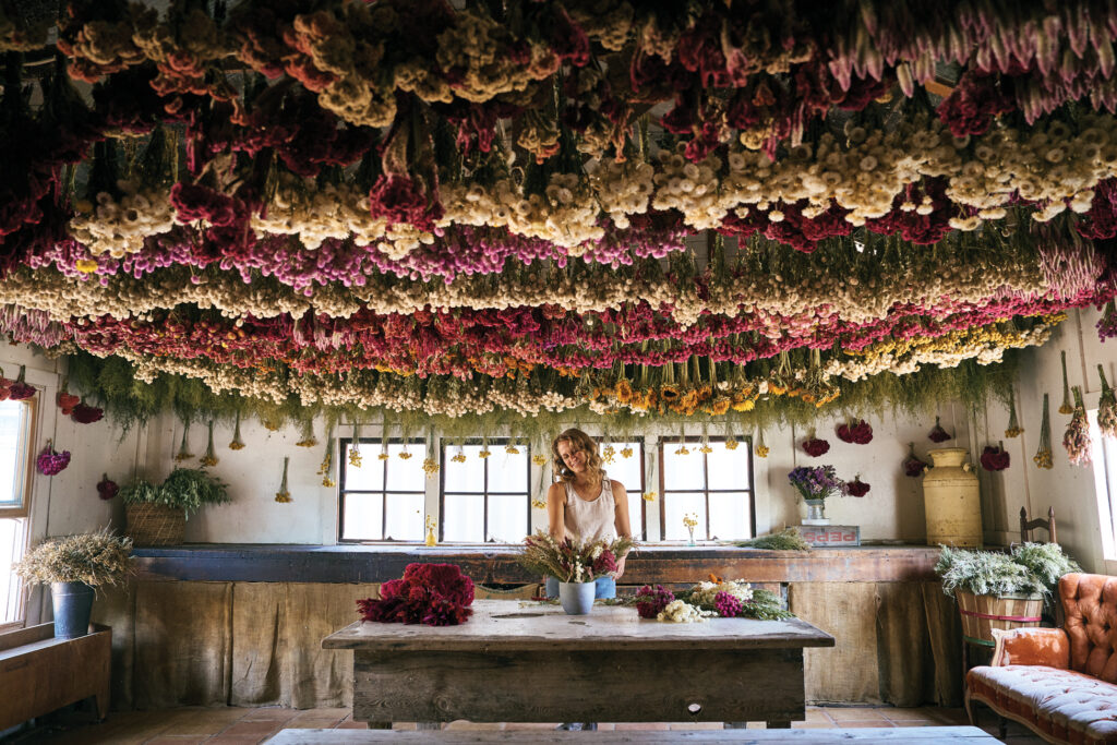 Muller Arranging Dried Flowers in Full Belly Farm Wreath Room