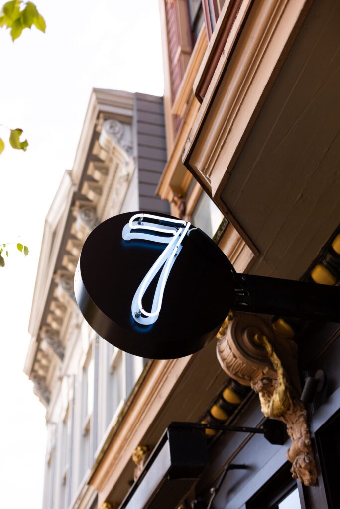 An outdoor restaurant sign with the number "7" lit up.