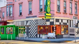 The exterior of a color restaurant featuring geometric patterns and a green and yellow sign with the name 
