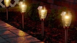 brass path lights in mulch by paved path