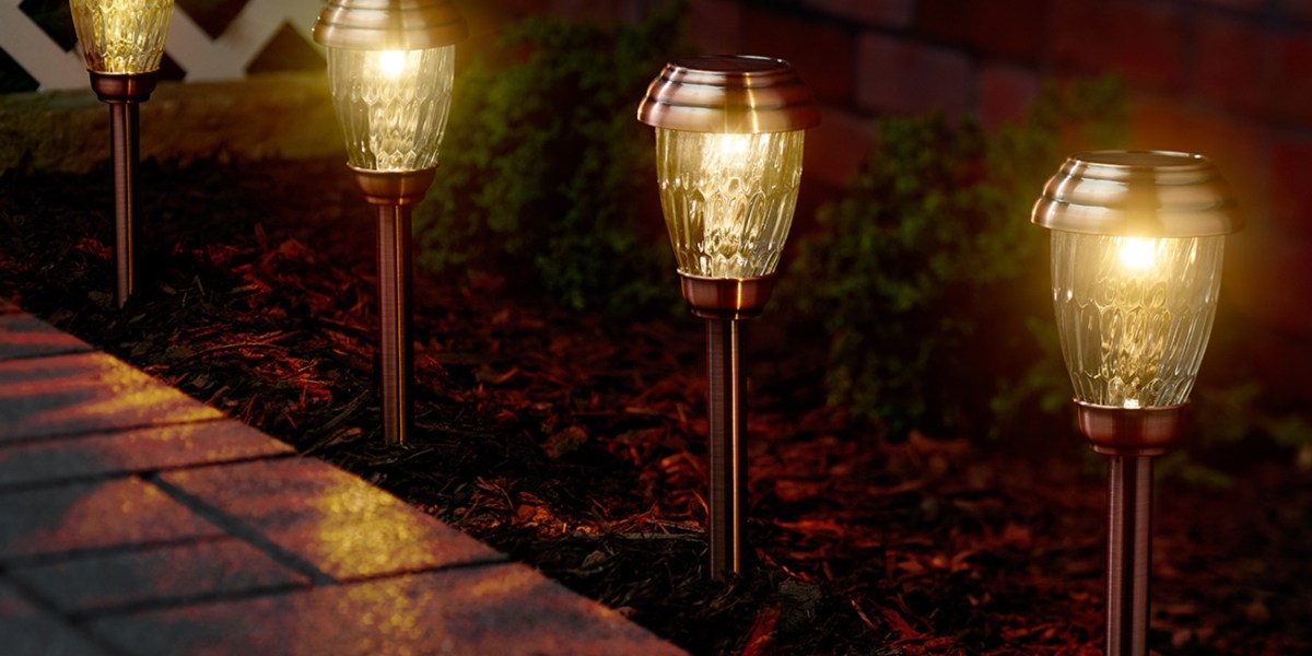 brass path lights in mulch by paved path