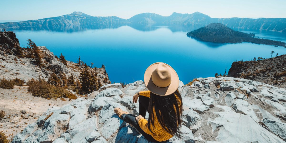 Woman in a Hat on a Rock Overlooking Crater Lake