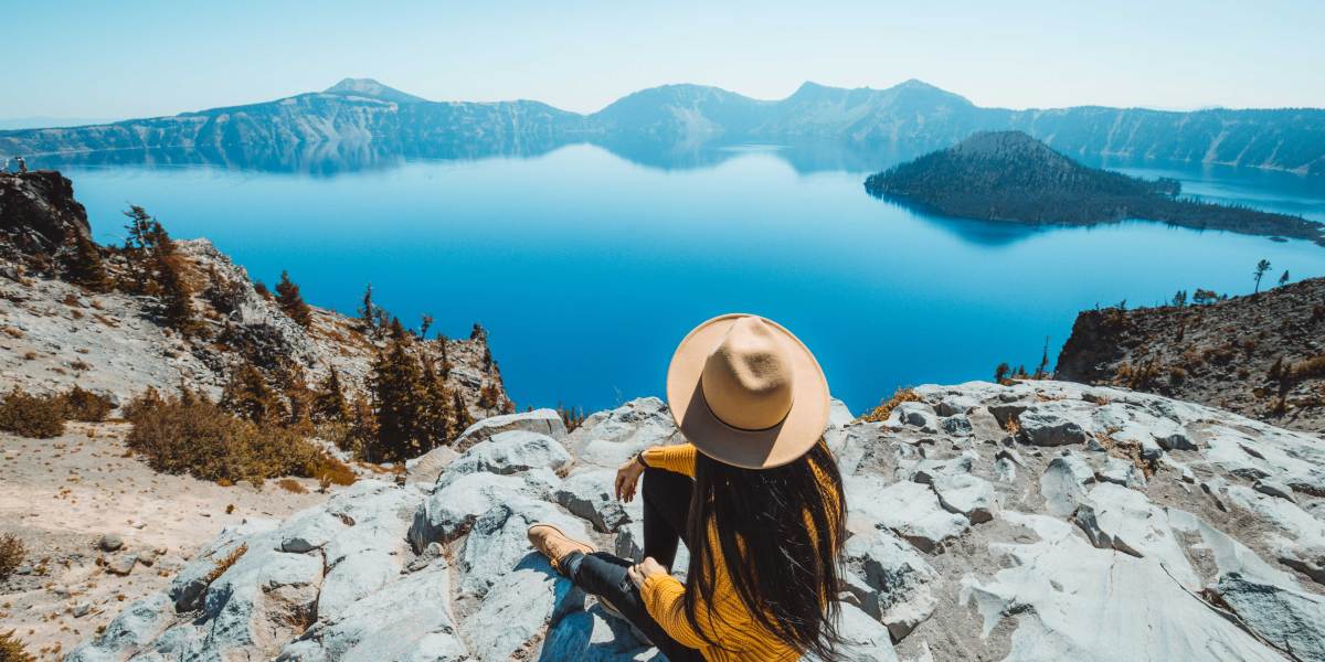 Woman in a Hat on a Rock Overlooking Crater Lake