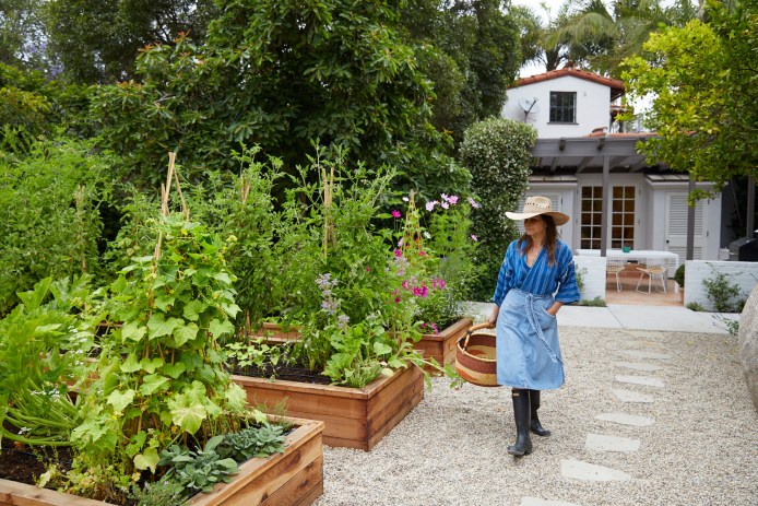 Lauri Kranz walking by raised beds with flowers
